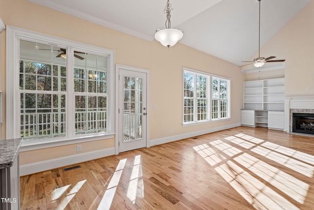 unfurnished living room with lofted ceiling, a fireplace, and light wood-type flooring