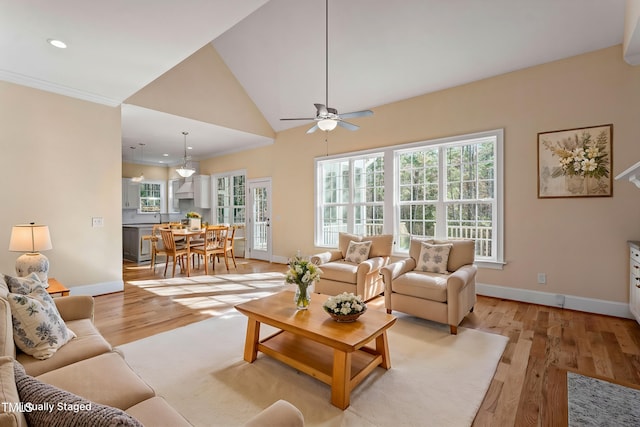 living room with high vaulted ceiling, ceiling fan, and light hardwood / wood-style floors