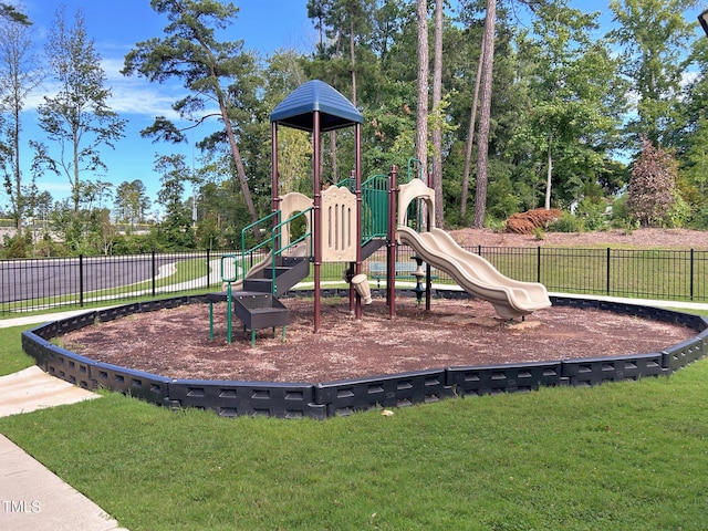 community playground featuring a lawn and fence