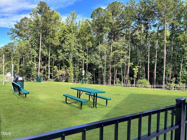 view of home's community with a yard and fence