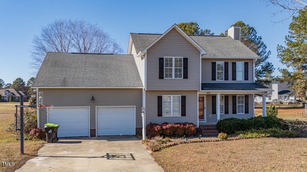 view of front facade featuring a front yard, a porch, and a garage