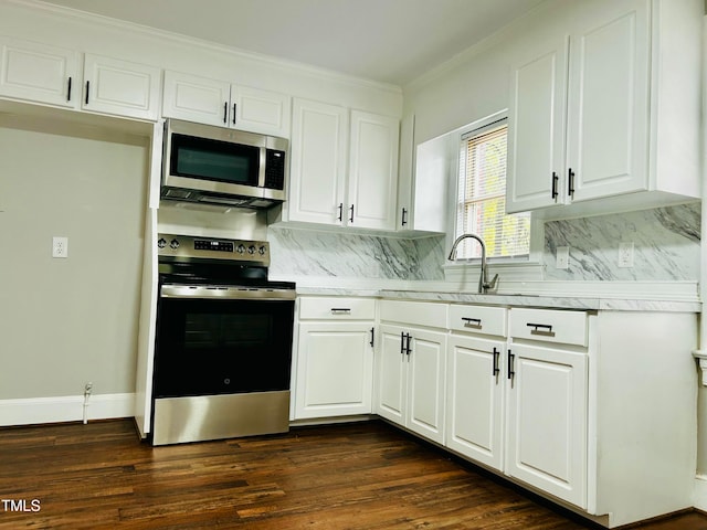 kitchen with decorative backsplash, appliances with stainless steel finishes, dark hardwood / wood-style flooring, ornamental molding, and white cabinets