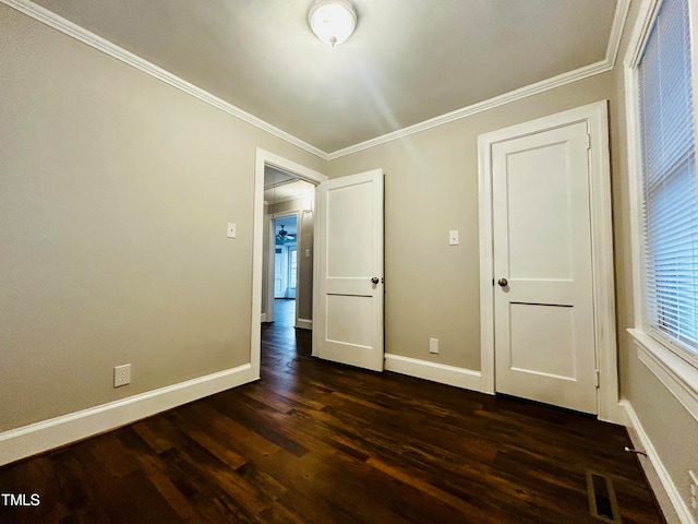 unfurnished bedroom with crown molding and dark wood-type flooring