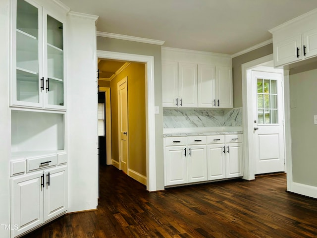 bar with backsplash, dark hardwood / wood-style floors, white cabinetry, and ornamental molding