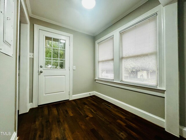 doorway to outside with dark hardwood / wood-style flooring and crown molding