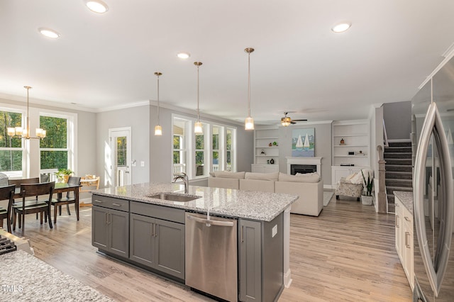 kitchen featuring sink, hanging light fixtures, light wood-type flooring, and appliances with stainless steel finishes