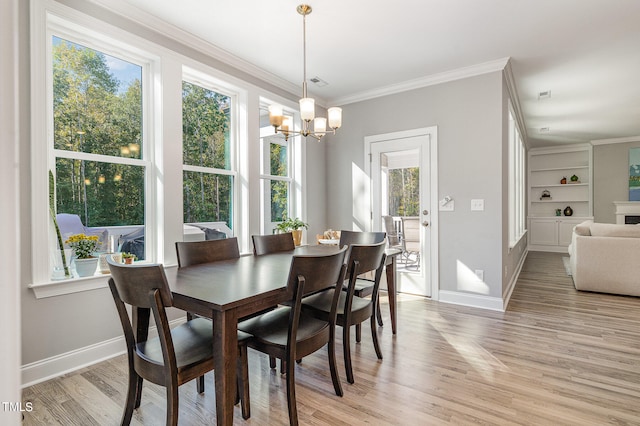 dining room featuring an inviting chandelier, crown molding, a wealth of natural light, and light hardwood / wood-style flooring