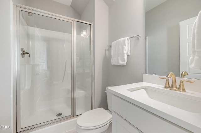 bathroom with vanity, toilet, and a shower with door