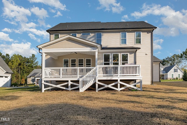 rear view of property featuring a porch, ceiling fan, and a lawn