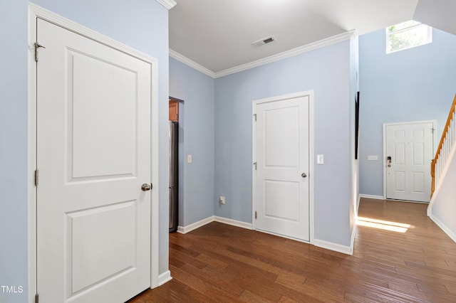 unfurnished bedroom with baseboards, ornamental molding, wood finished floors, and visible vents