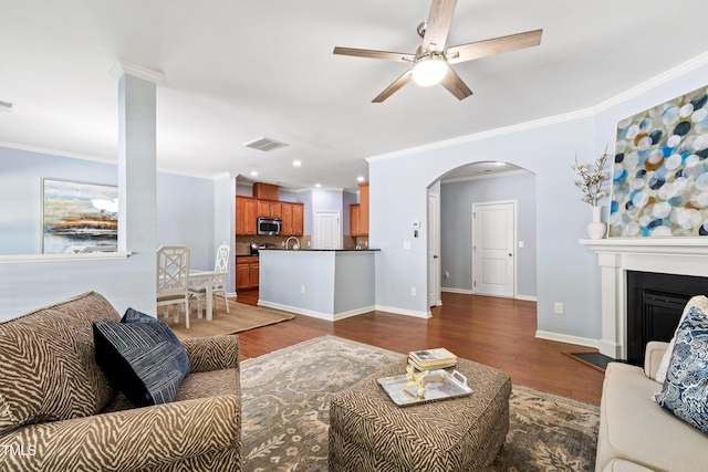 living room featuring crown molding, ceiling fan, dark wood finished floors, and visible vents