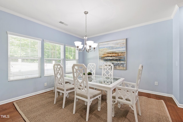 dining area featuring crown molding, visible vents, an inviting chandelier, wood finished floors, and baseboards