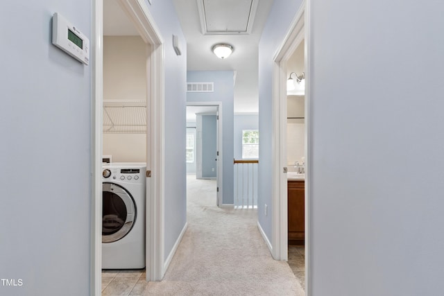 laundry room with laundry area, light colored carpet, attic access, washer / dryer, and visible vents