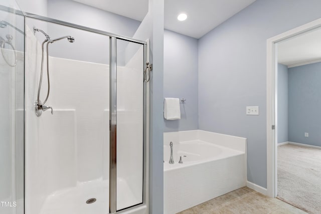 bathroom featuring baseboards, tile patterned flooring, a garden tub, and a stall shower
