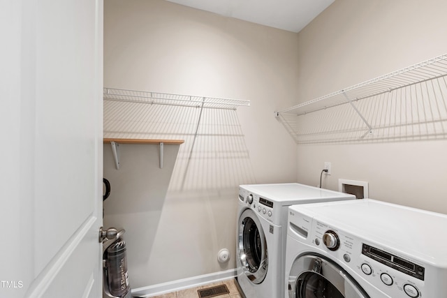 laundry area featuring baseboards, visible vents, laundry area, and washing machine and clothes dryer