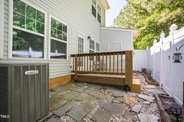 wooden deck with a fenced backyard and central AC unit
