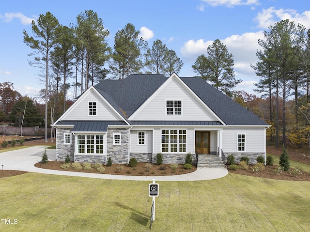 2637 Trifle Ln, Wake Forest, NC 27587 - view of front facade with stone siding, a standing seam roof, a front lawn, and a shingled roof
