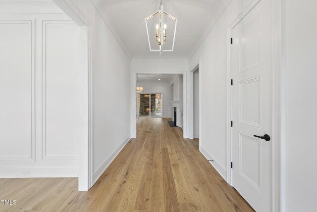 2637 Trifle Ln, Wake Forest, NC 27587 - hall featuring light wood finished floors, a chandelier, baseboards, and ornamental molding
