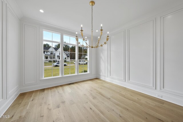 2637 Trifle Ln, Wake Forest, NC 27587 - unfurnished dining area with a decorative wall, a chandelier, plenty of natural light, light wood-type flooring, and crown molding