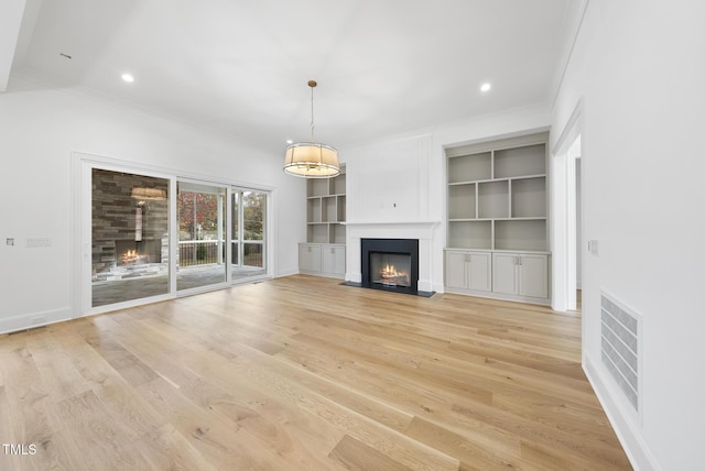 2637 Trifle Ln, Wake Forest, NC 27587 - unfurnished living room featuring a fireplace with flush hearth, crown molding, light wood-style floors, baseboards, and built in shelves