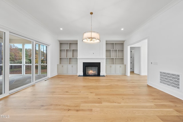 unfurnished living room with light wood-type flooring, ornamental molding, and an inviting chandelier