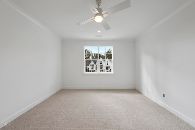 carpeted empty room featuring ceiling fan and crown molding