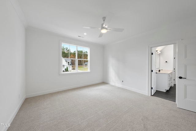 carpeted empty room with ceiling fan and crown molding