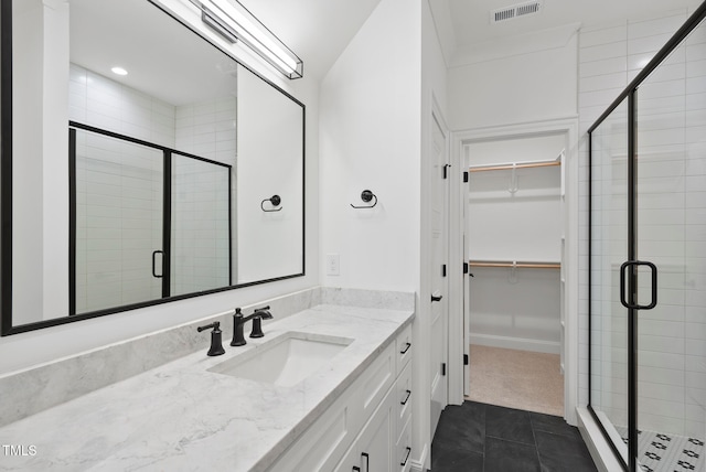 bathroom with tile patterned floors, vanity, and an enclosed shower