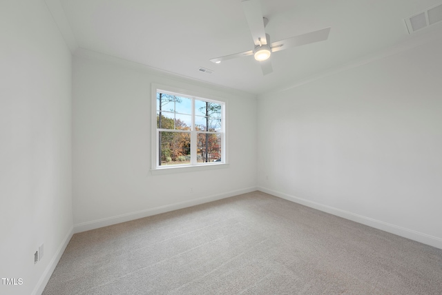 carpeted empty room with ceiling fan and ornamental molding