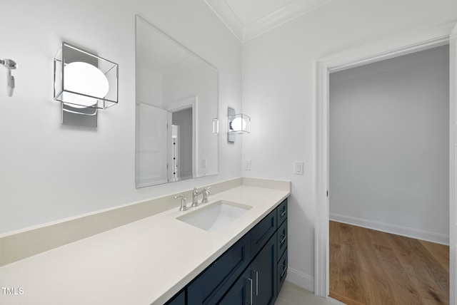 bathroom featuring hardwood / wood-style floors, vanity, and ornamental molding