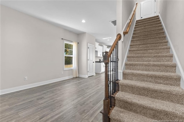 stairway with hardwood / wood-style floors