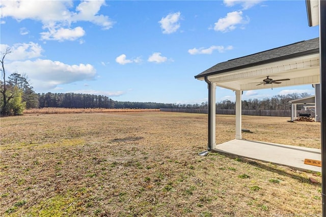 view of yard featuring a rural view and ceiling fan