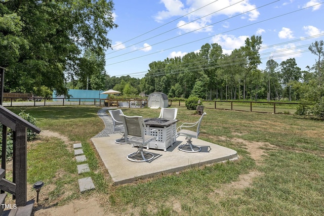 view of yard with a patio, a fire pit, and a shed