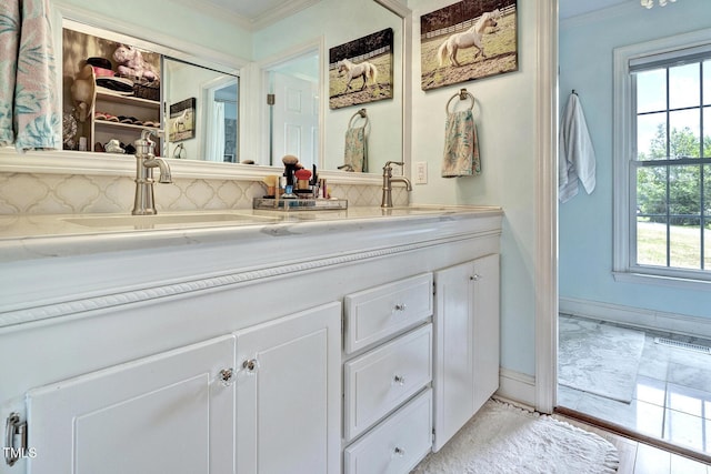 bathroom featuring vanity, a healthy amount of sunlight, and ornamental molding