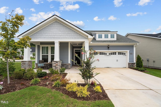 craftsman-style house featuring a garage, stone siding, a porch, and concrete driveway