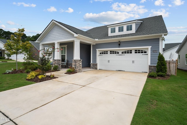 craftsman-style home with a porch, a garage, stone siding, driveway, and a front yard