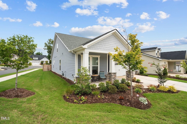 view of front facade featuring a garage, a porch, concrete driveway, and a front yard