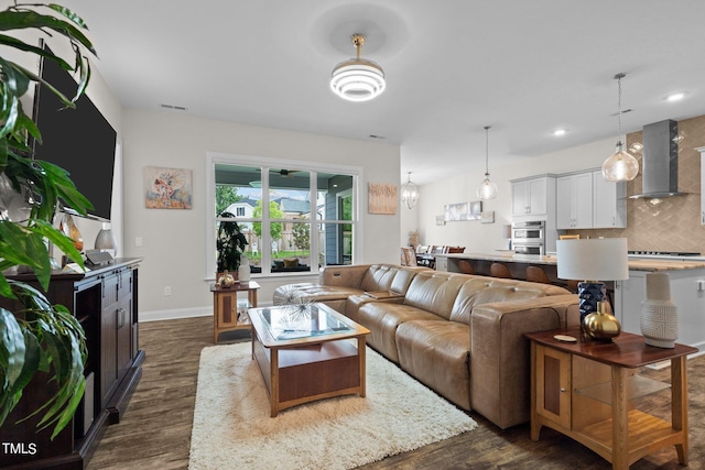 living area with recessed lighting, dark wood finished floors, visible vents, and baseboards