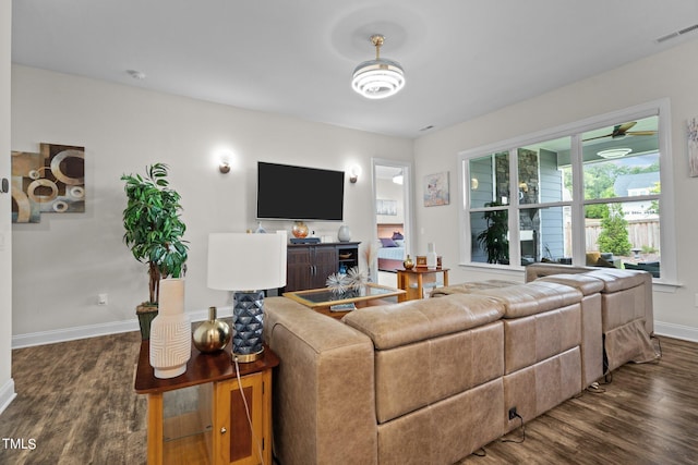 living area featuring dark wood-style floors, baseboards, and visible vents