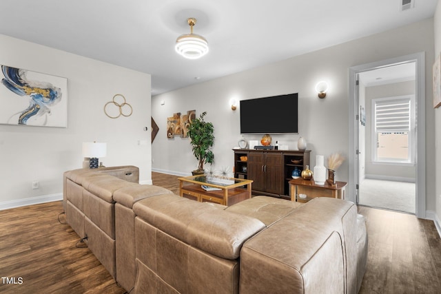 living area with baseboards and wood finished floors