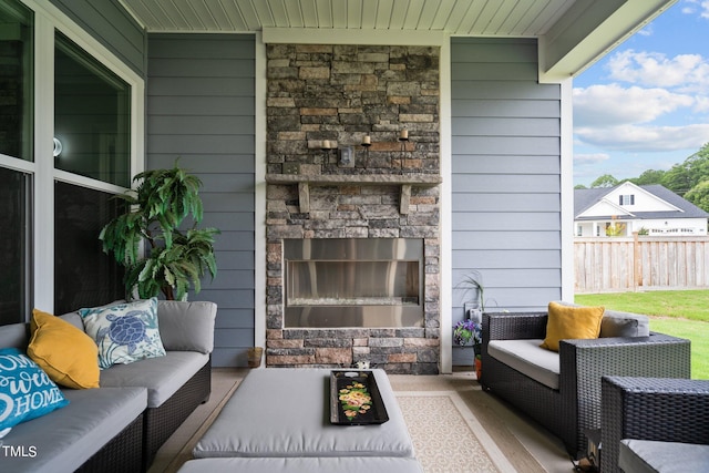 view of patio / terrace with fence and an outdoor living space with a fireplace