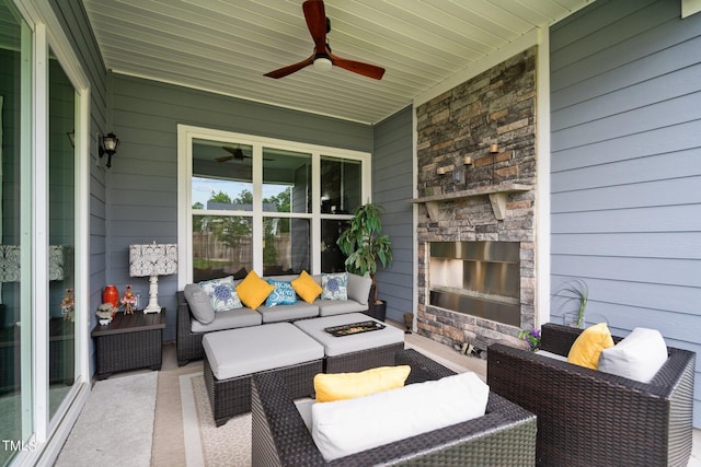 view of patio with an outdoor living space with a fireplace and ceiling fan