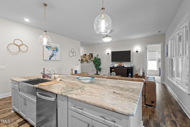 kitchen featuring dark wood-type flooring, open floor plan, decorative light fixtures, and an island with sink