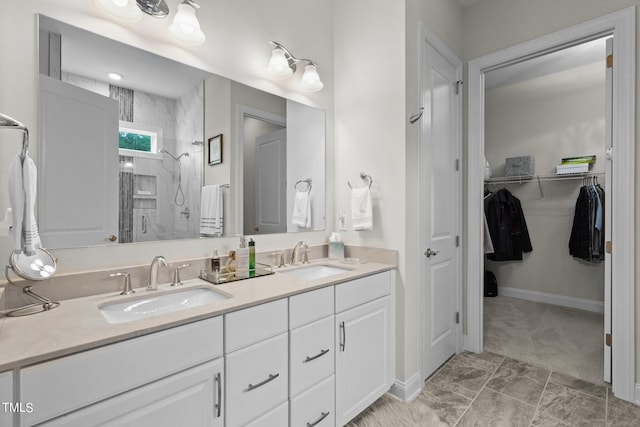 bathroom featuring double vanity, a spacious closet, a sink, and a shower stall