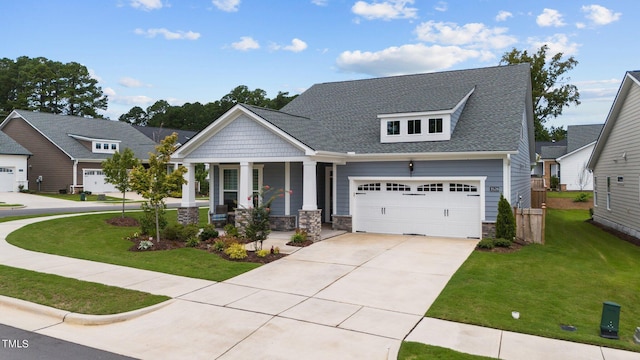 view of front of home featuring covered porch, stone siding, a front lawn, and concrete driveway