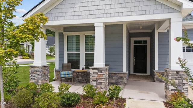 property entrance featuring stone siding and a porch