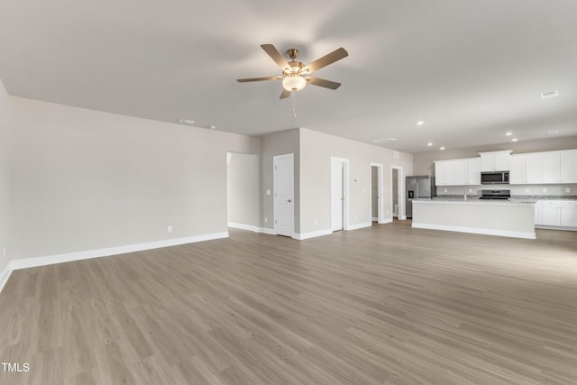 unfurnished living room featuring ceiling fan and light hardwood / wood-style floors