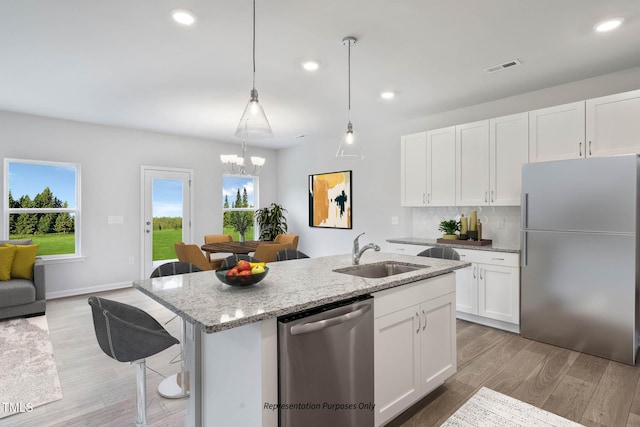 8816 Melvin St Unit 15-, Smithfield, Willow Springs, NC 27592 - kitchen with stainless steel appliances, a sink, light stone counters, light wood-style floors, and white cabinetry
