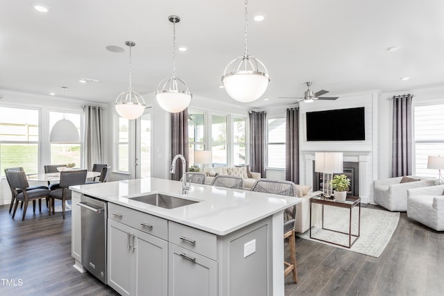 kitchen featuring open floor plan, light countertops, ornamental molding, and a sink