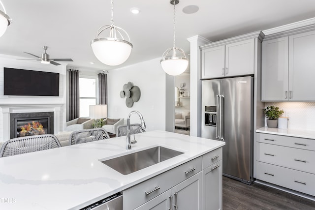 kitchen featuring a sink, backsplash, open floor plan, and high end fridge